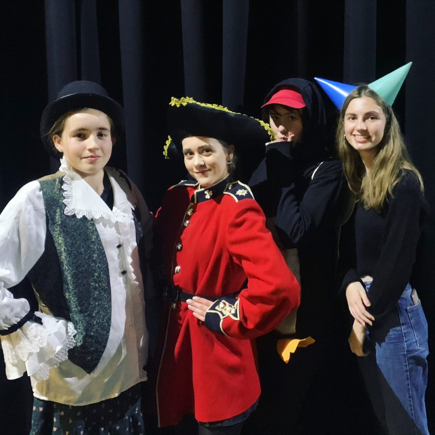 Four teenagers pose with some costumes